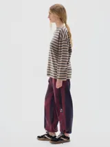 Remera de manga larga con calce holgado, confeccionada en algodón. Presenta un diseño a rayas horizontales en tonos beige y negro, con bordado de letras SP en el pecho y estampa de la marca en la manga.