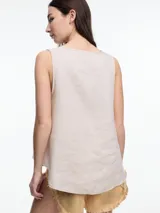 Top sin mangas de lino, color negro, con escote en V pronunciado y calce amplio. Presenta paneles laterales en color beige claro que asoman por debajo del negro.