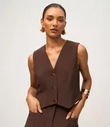Chaleco slim color marrón, confeccionado en crepé, con escote en V y abotonado frontal.