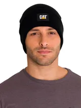 Gorro tipo beanie de tejido de punto acanalado en color negro, con vuelta en el borde y parche frontal con el logo de CAT.