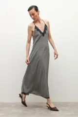 Vestido midi de tirantes finos con estampado de cuadros vichy en blanco y negro, escote en V y detalle de encaje en el dobladillo.