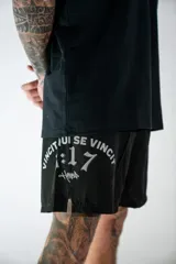 Short deportivo negro con aberturas laterales, confeccionado en tejido técnico. Presenta una estampa gráfica en color gris con la frase 'Vincit qui se vincit' y el número '1:17' junto al logo de la marca.
