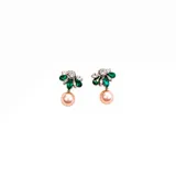 Caravanas de diseño floral con cristales en tonos verde y transparente, rematadas con una perla colgante en color rosado.