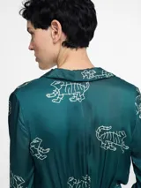 Vestido camisero largo color verde esmeralda con estampado de tigres blancos, cuello camisero, mangas largas y lazo en la cintura.