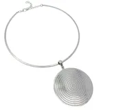 Gargantilla rígida en tono plateado con un dije circular grande de superficie texturizada con diseño de puntos concéntricos.