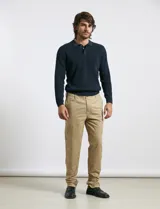 Remera de punto tipo polo con textura waffle, color verde petróleo, de manga larga y cuello con cierre de botones.