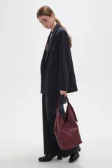 Bolso tipo shopper de cuero sintético en color bordó, con diseño de tejido trenzado en los laterales y doble asa.