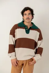 Buzo tejido de punto con diseño a rayas horizontales anchas en color marrón y beige. Presenta un cuello polo en color verde oscuro con cierre frontal de dos botones, mangas largas con puños elásticos y un corte boxy fit.