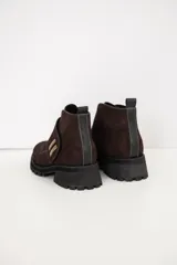 Bota corta de cuero color chocolate, con suela track y detalle de hebilla metálica dorada en el lateral.