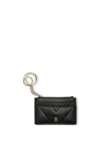 Tarjetero de cuero sintético negro con diseño acolchado, cuatro ranuras exteriores para tarjetas, un bolsillo con cierre y llavero metálico dorado con cadena.