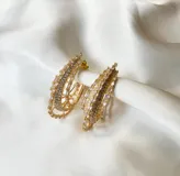 Aros tipo argolla dorados con diseño de múltiples aros y engarce de circonias.