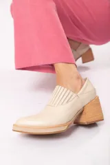 Zapato de cuero color beige con punta fina y taco de madera.