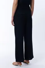 Pantalón negro de lino, de corte palazzo y tiro alto.