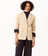 Blazer sastre color beige, de corte estructurado y calce al cuerpo, con solapa clásica, bolsillos con solapa en los laterales, bolsillo superior y cierre frontal de un botón.