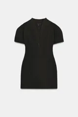 Vestido corto negro con escote en V, mangas cortas con volumen y cierre frontal con cremallera.