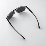 Lentes de sol polarizados de diseño clásico, con armazón de acetato transparente en tono gris y cristales oscuros.