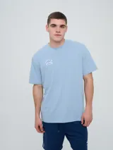 Remera Umbro de manga corta, color celeste, con cuello redondo y el logo de la marca bordado en el pecho.