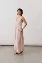 Vestido largo color amarillo con tirantes finos cruzados en la espalda, escote en V y diseño fluido con falda amplia.