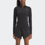 Buzo deportivo Reebok para mujer, color negro, de manga larga y cuello alto con cierre de un cuarto. Presenta paneles de malla en los laterales y logo reflectante en el pecho.
