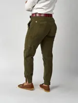 Pantalón de pana negro de corte recto, con bolsillos laterales y traseros. Se ajusta a la cintura con cinturón de cuero negro.