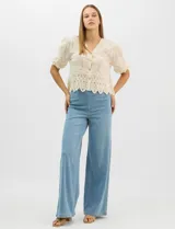 Jegging de tiro alto con silueta estilo palazzo y pierna amplia. Confeccionado en tejido denim con pretina ancha elástica, sin cierre frontal. Presenta diseño frontal liso sin bolsillos y dos bolsillos traseros tipo parche.