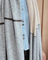 Bufandón de lana lambswool, de textura suave y liviana, con diseño liso y etiqueta de cuero en el extremo inferior.