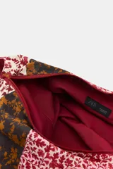 Maxi bolsa estilo hobo confeccionada en algodón 100%, con diseño patchwork de estampado floral en tonos bordó, beige, negro y rosado. Cuenta con asa integrada para el hombro.