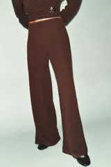 Pantalón de tiro alto con cintura elástica y diseño de pernera ancha, confeccionado en tejido de punto con textura.