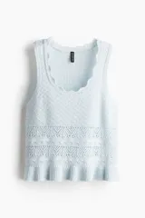 Musculosa de punto suave con diseño estilo crochet, escote redondo con borde festoneado y ruedo con volado acanalado.