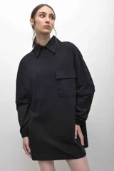 Remerón negro con cuello camisero, mangas largas con puños elásticos y bolsillo con solapa en el pecho.