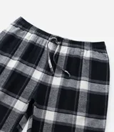 Pantalón de pijama de corte recto confeccionado en franela de algodón con estampado de cuadros en tonos blanco y negro. Presenta cintura elástica con cordón de ajuste para mayor comodidad.