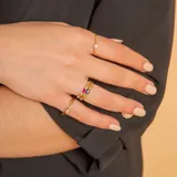 Anillo de oro 9k con piedra central de rubí en talla ovalada. Diseño minimalista y elegante.