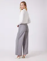Pantalon de corte wide leg en color gris, con cintura elastizada y franjas laterales en contraste. Presenta un diseño de pierna recta y holgada.
