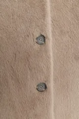 Chaqueta corta de cuello redondo y manga larga, confeccionada en tejido sintético con acabado efecto pelo. Presenta cierre frontal con botones a tono.