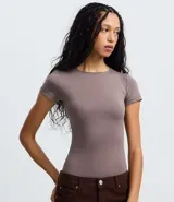 Body de cuello redondo y manga corta, confeccionado en tejido de poliamida con elastano. Presenta un diseño liso y ajustado al cuerpo con cierre en la entrepierna.