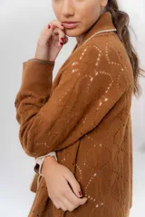 Saco tejido de lambswool color marrón, con diseño inspirado en kimono, mangas largas y delicados calados en toda la prenda. Cuenta con bordes en contraste.