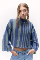 Sweater corto tejido de punto a rayas verticales azules y verdes texturizado con lurex. Cuenta con un calce oversize, mangas tres cuartos y cuello bote.
