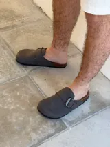 Zuecos grises con hebilla metálica ajustable y plantilla anatómica de corcho.