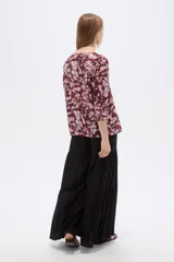 Blusa de viscosa bordó con estampado abstracto, escote en V con cuello tipo solapa y mangas 3/4, de corte holgado.