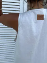 Vestido playero de corte holgado y diseño minimalista, confeccionado en algodón. Presenta cuello redondo, sisas amplias y aberturas laterales en el ruedo con pespuntes en contraste.