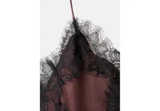 Top de satén color marrón oscuro con finos tirantes y detalles de encaje negro en el escote y el bajo asimétrico.