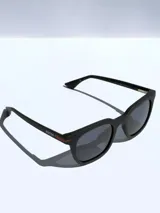 Lentes de sol marca Osten modelo Oslo 2601, con armazón de pasta color negro mate y detalle en color naranja en las patillas. Cuentan con cristales oscuros polarizados con protección UV 400.