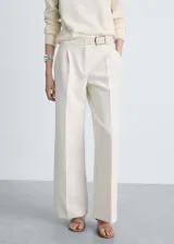 Pantalón de vestir color crema, de tiro medio y corte recto. Incluye cinturón decorativo y bolsillos laterales.