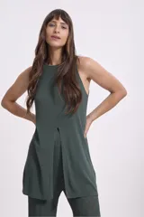 Blusa tejida sin mangas, de corte largo y holgado, con cuello redondo y tajo frontal central.