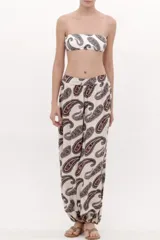 Pantalón de corte fluido color beige con estampado paisley en tonos oscuros, tiro alto con lazo para anudar en la cintura y botamangas con elástico.