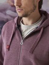 Buzo tipo hoodie con cierre frontal completo, capucha con cordones ajustables y bolsillos laterales. Confeccionado en tejido de algodón con textura jaspeada.