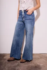 Pantalón de jean de tiro medio, color celeste, corte flared y wide leg.