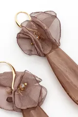 Par de aros colgantes de diseño alargado, con pieza superior de tela semitransparente fruncida en tono marrón y gran dije colgante de acrílico en forma de gota con efecto marmolado.