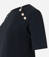 Blusa negra de crepé con cuello redondo, mangas cortas y botones dorados decorativos en los hombros.