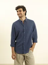 Camisa de manga larga confeccionada en una mezcla de algodón y lino, con cuello abotonado, cierre frontal de botones y un bolsillo en el pecho.